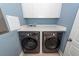 Well-equipped laundry room with white cabinets, solid surface countertop, and modern front-load washer and dryer at 2734 Battle Trail Dr, Johns Island, SC 29455