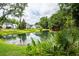 Beautiful pond view framed by trees, from this well-landscaped backyard at 2734 Battle Trail Dr, Johns Island, SC 29455