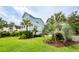 Spacious green yard with various palm trees and landscaping around the light blue two-story home at 2734 Battle Trail Dr, Johns Island, SC 29455