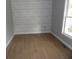 Bright bedroom featuring wood-look flooring, a window, and a shiplap accent wall at 301 Archibald Dr, Goose Creek, SC 29445
