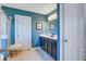 Well-lit bathroom with blue walls, featuring a vanity with drawers, and a glass door shower at 3306 Hartwell St, Johns Island, SC 29455