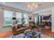 Bright living room featuring a leather sofa, decorative pillows, large windows, and a modern chandelier at 3306 Hartwell St, Johns Island, SC 29455