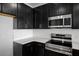 Close-up of modern kitchen featuring sleek dark cabinets, stainless steel appliances, and white subway tile backsplash at 331 Bremerton Dr, Goose Creek, SC 29445