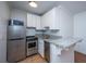 Efficient kitchen features stainless steel appliances, bright white cabinets, and a granite countertop at 338 King St # C, Charleston, SC 29401