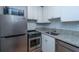 Efficient kitchen features stainless steel appliances, bright white cabinets, granite countertop, and subway tile at 338 King St # C, Charleston, SC 29401