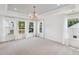 Bedroom featuring white walls, a tray ceiling, lots of windows, and a modern chandelier at 3802 Grateful Rd, North Charleston, SC 29420