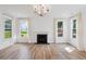 Living room with fireplace, wood floors, white shiplap accent wall, and bright windows at 3802 Grateful Rd, North Charleston, SC 29420