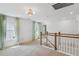 Carpeted loft area featuring two windows and wooden railing overlooking downstairs at 3802 Grateful Rd, North Charleston, SC 29420