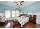 Spacious main bedroom with tray ceilings, wainscoting, a ceiling fan, and hardwood floors at 415 True North Trail, Summerville, SC 29486