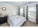 Well-lit bedroom with a full-sized bed, an exterior door, bedside table and a comfortable interior space at 415 True North Trail, Summerville, SC 29486