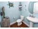 Fun powder room features coastal accents, a pedestal sink, and hardwood floors at 415 True North Trail, Summerville, SC 29486