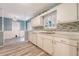 Kitchen with white cabinets, tile backsplash, and wood-look flooring at 4606 Moss Ct, North Charleston, SC 29420