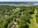 Aerial view of a property featuring lush greenery, a golf course, waterfront, and a beautiful landscape at 5195 Forest Oaks Dr, Hollywood, SC 29449