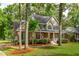 Charming two-story home with a brick facade, manicured landscaping, an American flag, and a welcoming front porch at 5195 Forest Oaks Dr, Hollywood, SC 29449