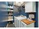Organized laundry room featuring a modern washer and dryer, built-in shelves with storage, and counter space with a butcher block top at 5195 Forest Oaks Dr, Hollywood, SC 29449