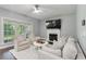 Cozy living room with plush seating, fireplace, and natural light from large windows at 5195 Forest Oaks Dr, Hollywood, SC 29449