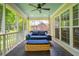 Relaxing screened porch with a porch swing, ceiling fan, and wicker accents, offering a view of the backyard at 5195 Forest Oaks Dr, Hollywood, SC 29449