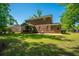 Brick home showcasing a spacious backyard with green lawn and screened-in patio at 5442 Clearview Dr, North Charleston, SC 29420