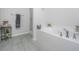 A bright bathroom features a deep soaking tub, gray tile floors, and minimalist decor at 5442 Clearview Dr, North Charleston, SC 29420