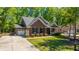 Charming brick home with a well-manicured lawn, attached garage, and a cozy front porch, nestled among mature trees at 5442 Clearview Dr, North Charleston, SC 29420
