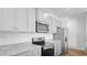 Stylish kitchen boasts gray cabinets, granite counters, stainless steel appliances, and sleek hardwood floors at 6039 Savy Ct, Ravenel, SC 29470