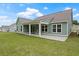 Spacious backyard features a covered patio, a lush green lawn, and a home with white trim at 769 Maynard Ln, Summerville, SC 29486