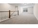Spacious loft area with plush carpeting, natural light, and an elegant wood and white railing at 769 Maynard Ln, Summerville, SC 29486
