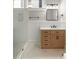 Bright bathroom featuring a wooden vanity, a black faucet, and marble tile flooring at 8 Pitt St # A, Charleston, SC 29401