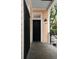 Front porch with a black screen door, an exterior light fixture, and trees in the background at 8 Pitt St # A, Charleston, SC 29401