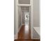 A hallway view that features hardwood floors and neutral wall paint, with an open doorway leading to another room at 8 Pitt St # A, Charleston, SC 29401