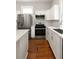 A well lit kitchen featuring quartz countertops, white cabinets, stainless appliances, and hardwood floors at 8 Pitt St # A, Charleston, SC 29401