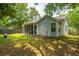 Exterior view of the house from the backyard with a lush lawn and mature trees at 8507 William Moultrie Dr, North Charleston, SC 29420