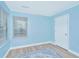 This bedroom features wood-look flooring, light blue walls, and natural light from a window at 8507 William Moultrie Dr, North Charleston, SC 29420