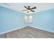 A serene bedroom boasts wood-look floors, calming light blue walls, and a ceiling fan for added comfort at 8507 William Moultrie Dr, North Charleston, SC 29420