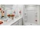 Well-lit bathroom featuring double sinks with white countertops and a walk-in shower with tiled walls at 8840 Shovelnose Ct, North Charleston, SC 29406