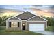 Charming single-story home with gray siding, white trim, and an attached garage, beautifully landscaped with colorful flowers at 8858 Shovelnose Ct, North Charleston, SC 29406