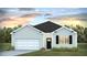 Charming single-story home featuring a single-car garage, black door, and tasteful landscaping at 8861 Shovelnose Ct, North Charleston, SC 29406