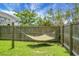 Lush green backyard with a hammock strung between wooden posts and a sturdy fence at 8921 Skipping Rock Ln, Summerville, SC 29485