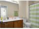 Bathroom with a double sink vanity, a toilet, and a shower with green-and-white striped curtain at 8921 Skipping Rock Ln, Summerville, SC 29485