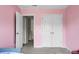 Bedroom featuring pink walls, closet, entry doors, and neutral carpet at 8921 Skipping Rock Ln, Summerville, SC 29485
