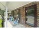 A charming front porch view with brick accent wall, blue chairs, and an inviting front door at 925 Dills Bluff Rd # 34, Charleston, SC 29412