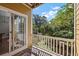 Outdoor balcony with wooden flooring and white railing overlooking lush trees and greenery at 9313 Sweetbay Ct, Ladson, SC 29456