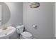 Powder room featuring pedestal sink, toilet, round mirror, and simple wall art at 9313 Sweetbay Ct, Ladson, SC 29456