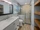 Modern bathroom featuring a tiled shower, marble countertop vanity, and stylish wood-look tile flooring at 932 Portabella Ln, Charleston, SC 29412