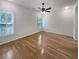 A large, bright bedroom with hardwood floors, a ceiling fan, and two large windows at 932 Portabella Ln, Charleston, SC 29412
