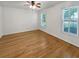 Bright bedroom with hardwood floors, ceiling fan and double hung windows with mini blinds at 932 Portabella Ln, Charleston, SC 29412