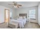 This bedroom features a ceiling fan, a bed with nightstands, and an attached bathroom at 100 Cicero Ct, Goose Creek, SC 29445