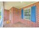 Inviting front porch featuring a brick exterior, a window with blue shutters, and decorative lighting fixtures at 100 Cicero Ct, Goose Creek, SC 29445