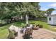 Backyard with a stone patio, outdoor seating, and a fire pit surrounded by mature trees and landscaping at 100 Conset Bay Ct, Goose Creek, SC 29445