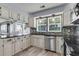 Bright kitchen features white cabinets, dark countertops, stainless steel appliances, and decorative backsplash at 100 Conset Bay Ct, Goose Creek, SC 29445